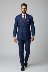 Man wearing navy double-breasted suit with peak lapels and tailored fit.
