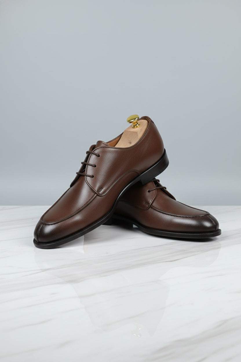 Brown leather lace-up dress shoes with classic design for formal occasions.