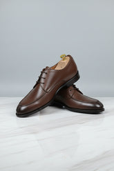 Brown leather lace-up dress shoes with classic design for formal occasions.