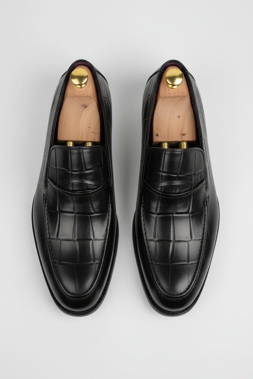 Black leather textured loafers with elegant design for formal occasions.