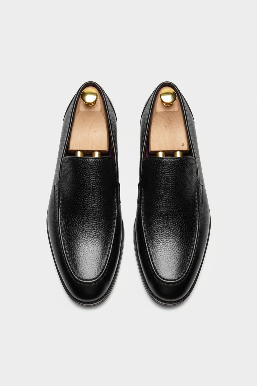 Black slip-on leather tuxedo shoes with textured finish and elegant design.