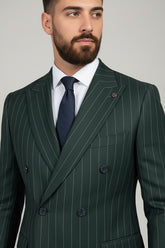 Man wearing green pinstripe double-breasted suit with tailored fit and navy tie.
