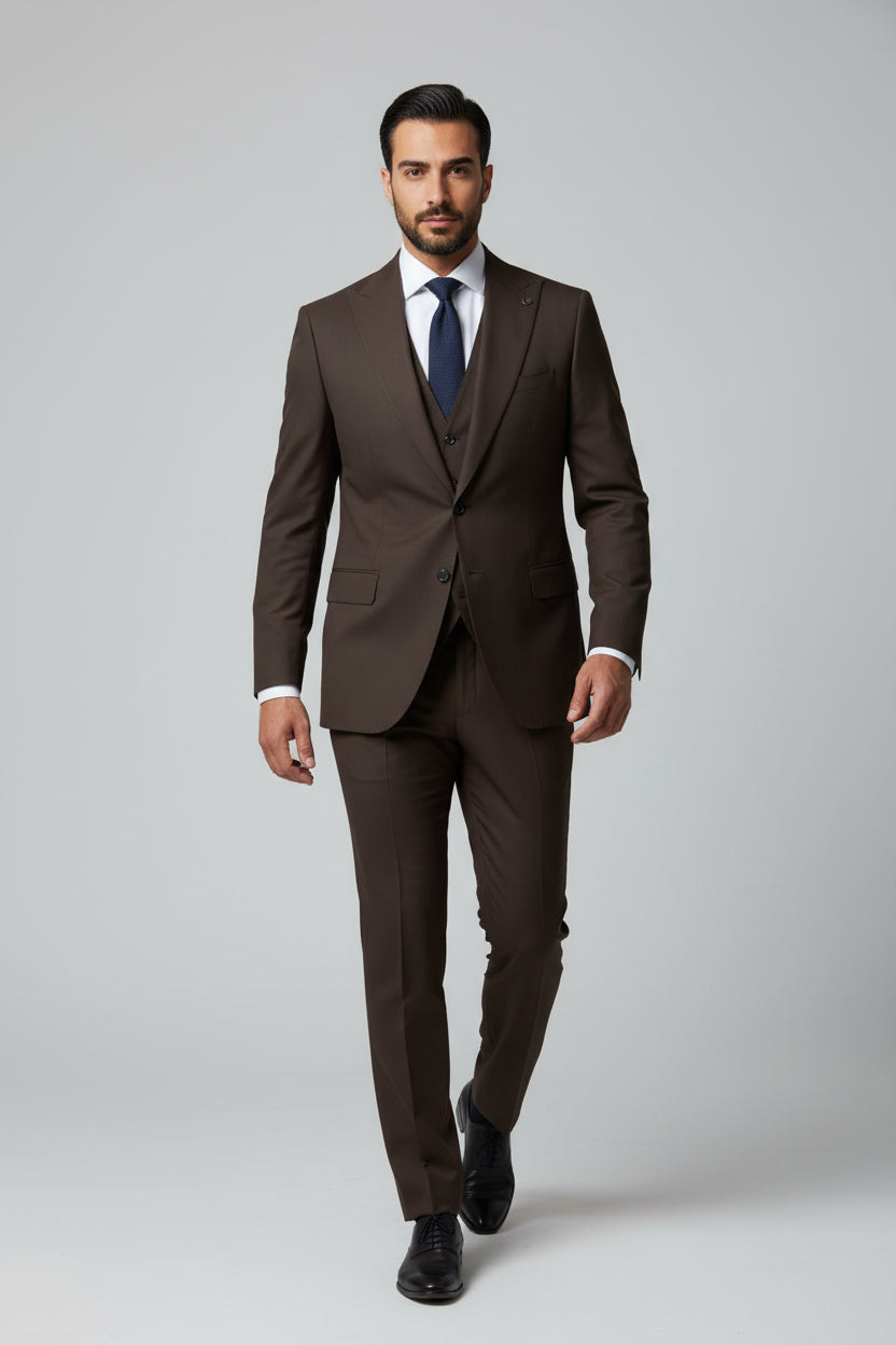 Man wearing brown slim fit three-piece suit with tailored vest and tie.