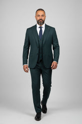 Man wearing green three-piece suit with notch lapel, perfect for weddings or business events.
