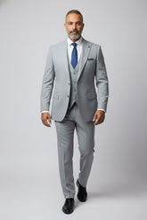 Man wearing light grey tailored fit three-piece suit with single-breasted jacket.