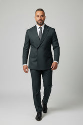 Man wearing dark green double-breasted suit with peak lapels and slim fit.