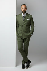Man wearing olive double-breasted suit with peak lapels, tailored fit for formal events.