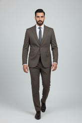 Man in brown three-piece suit with tailored fit, complete with waistcoat and tie.