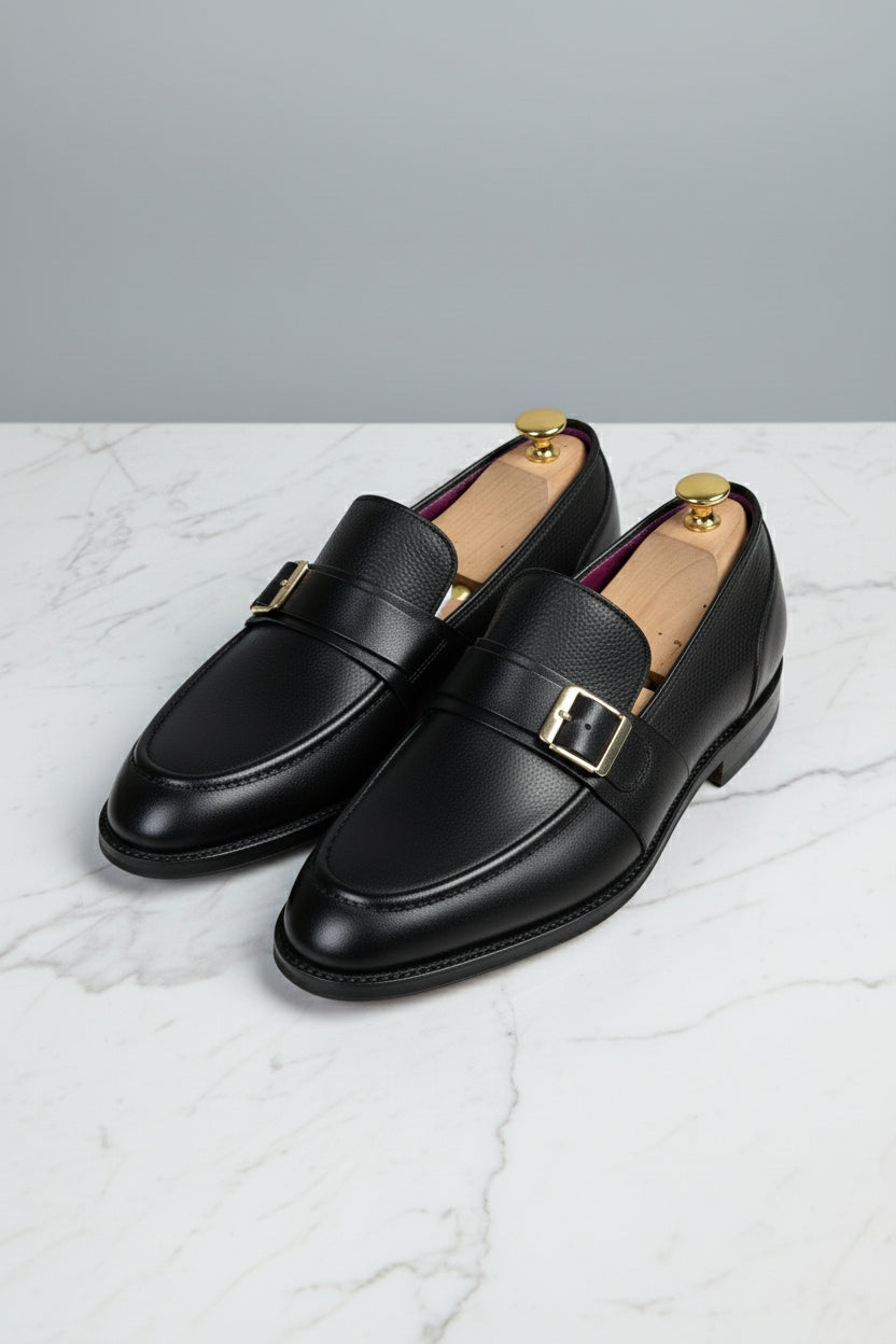 Black leather dress shoes with buckle detail, perfect for formal wear and business occasions.