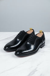 Black brogue Oxford shoes with contrast lining, perfect for formal and business occasions.