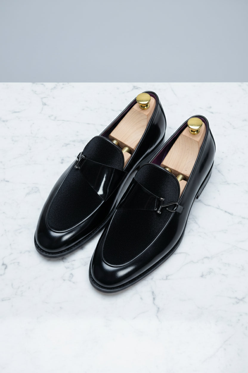 Black velvet loafer with elegant buckle detail, perfect for formal wear and events.