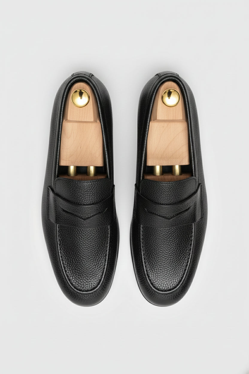 Black textured leather slip-on loafer with elegant design and comfortable fit.