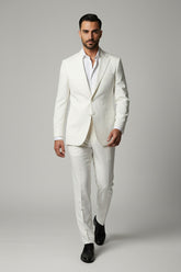 Man wearing a white two-piece performance suit with peak lapels for formal events.