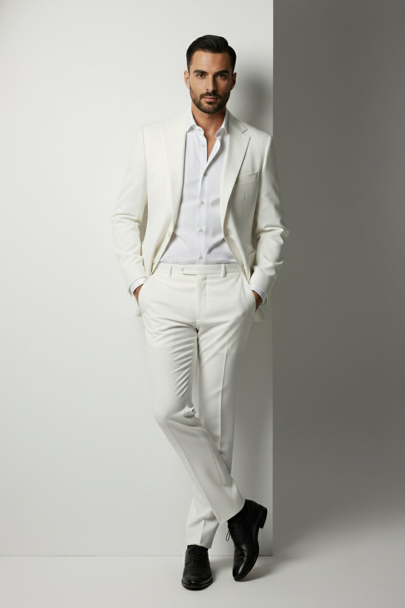 Man wearing white two-piece performance suit with peak lapels, tailored fit, and elegant style.