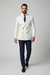 Man wearing white and navy pinstripe double-breasted suit with tailored fit.