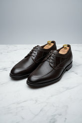 Brown leather lace-up dress shoes with textured finish and classic design.