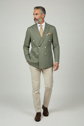 Man in sage green double-breasted suit with beige trousers, perfect for summer events.
