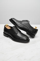 Black leather Oxford shoes with classic design and durable finish, perfect for formal occasions.
