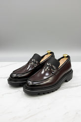 Burgundy leather slip-on loafers with stylish detailing and comfortable soles.
