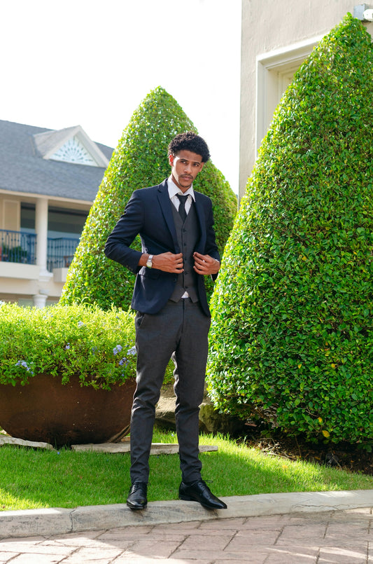 man in black suit standing on green grass field