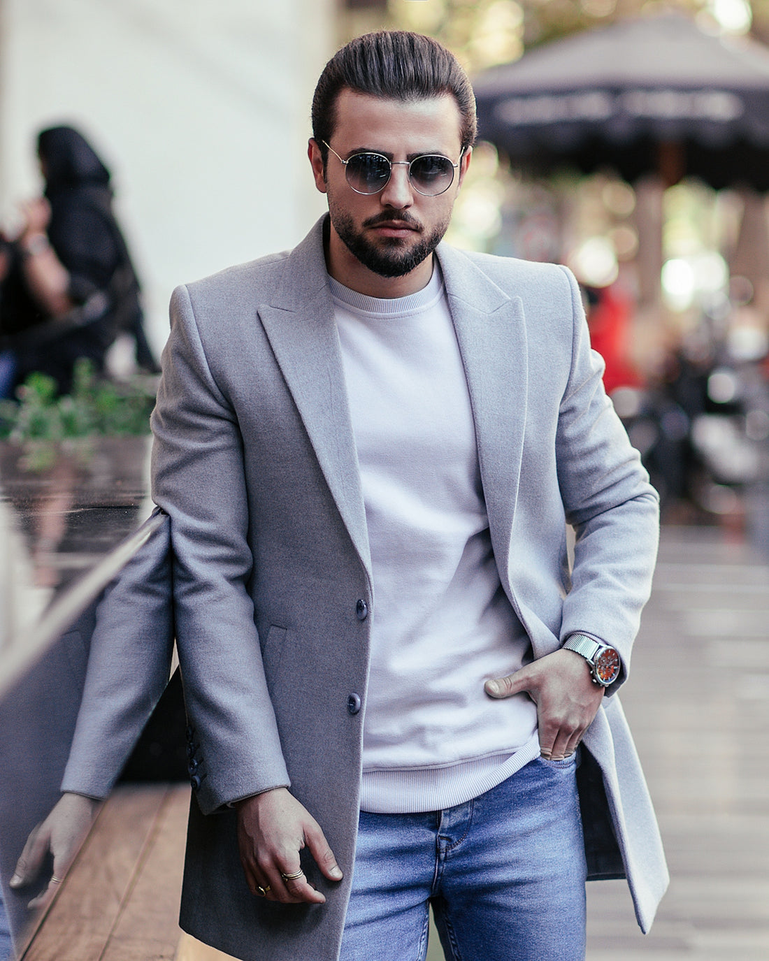 a man with a beard wearing a gray coat