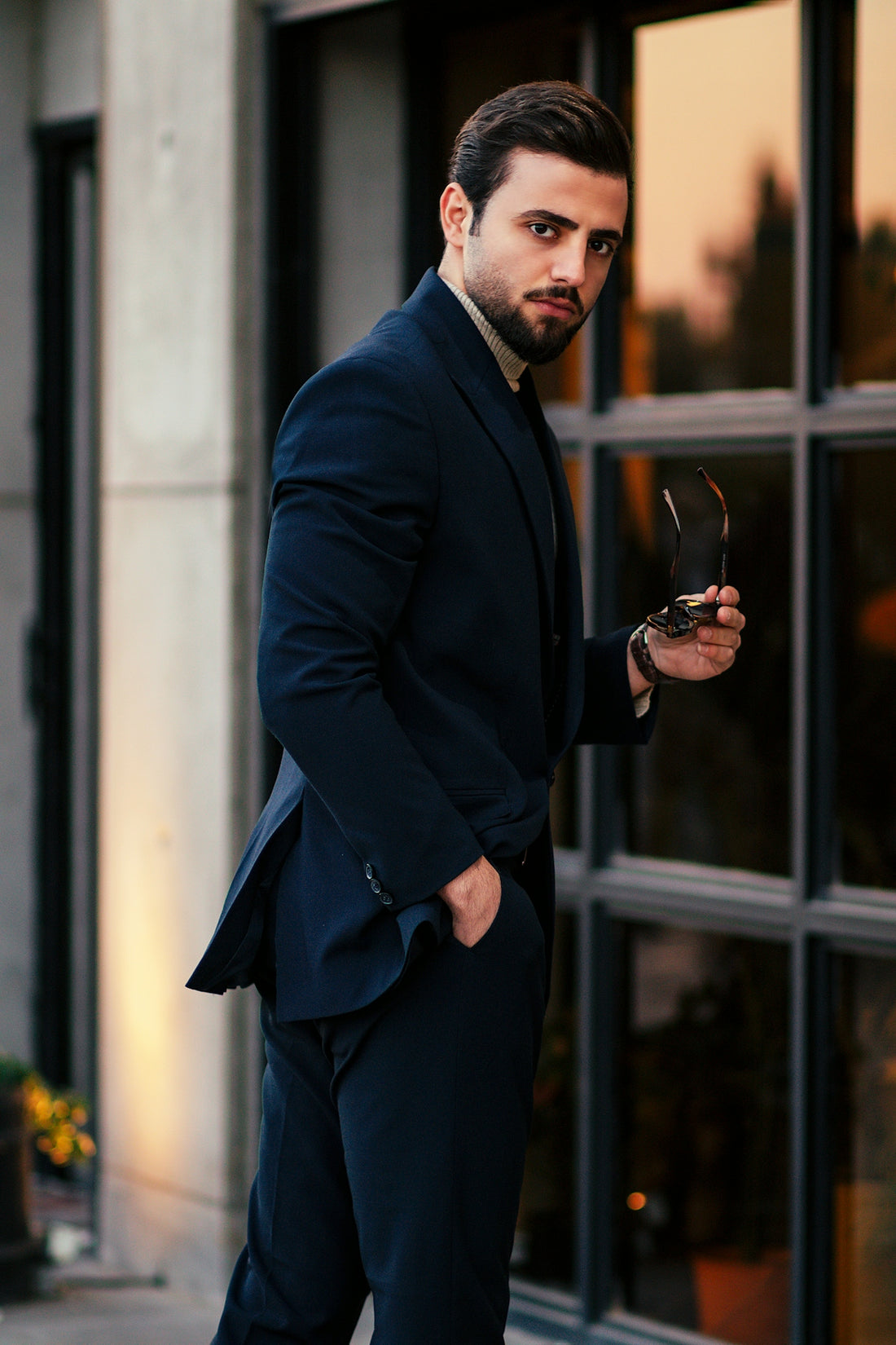 a man in a suit holding a pair of scissors