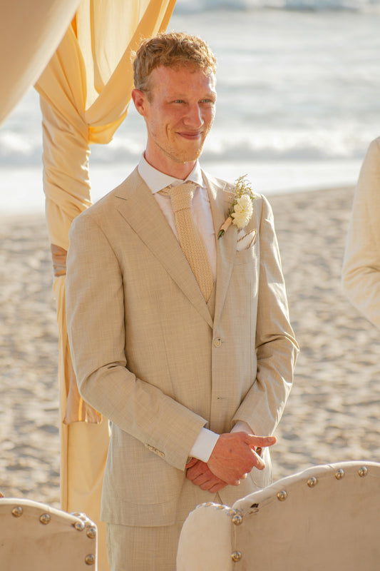 Groom smiling at beach wedding ceremony