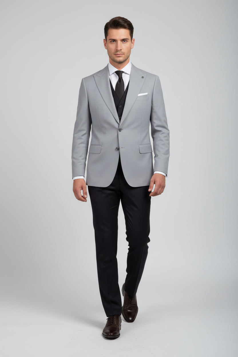 Man wearing light grey double-breasted suit with tailored fit and black tie.