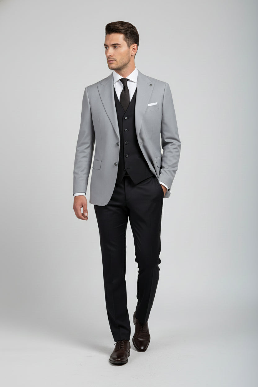 Man wearing light grey double-breasted suit with tailored fit and black vest.