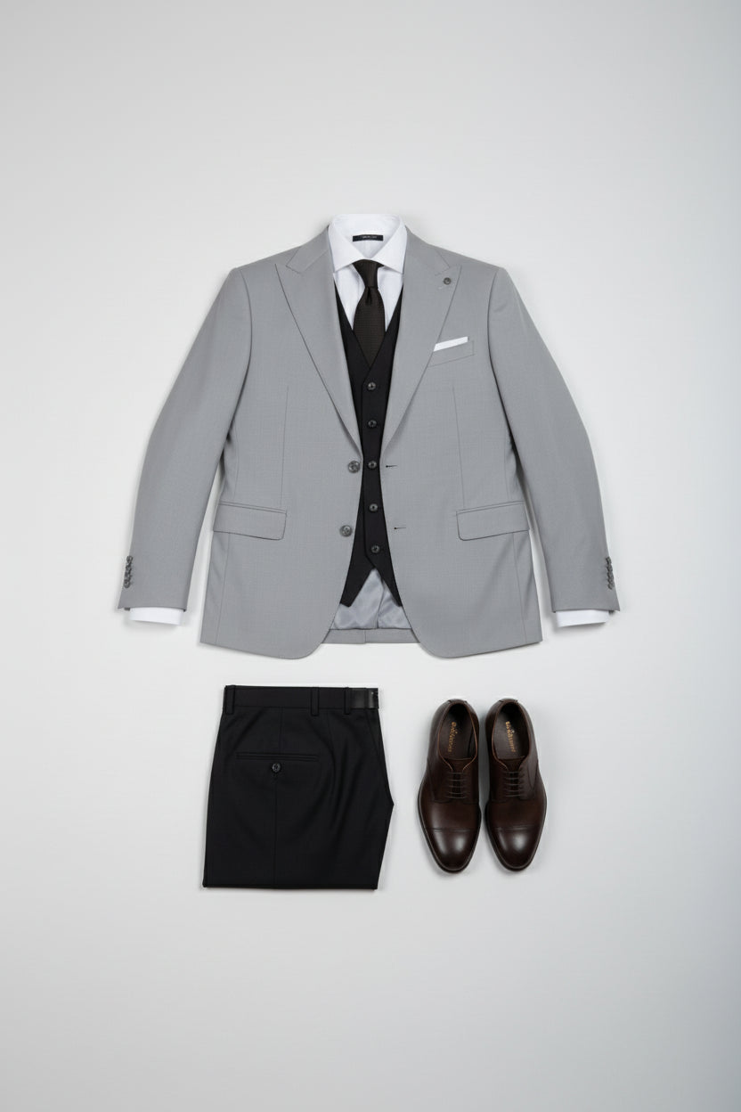 Light grey double-breasted suit with tailored fit, paired with dark trousers and brown shoes.