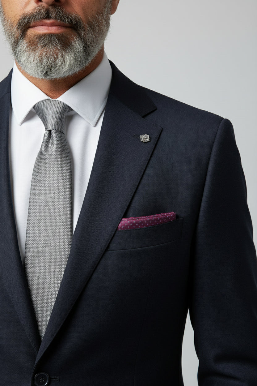 Man wearing navy slim fit suit with paisley lining and stylish pocket square