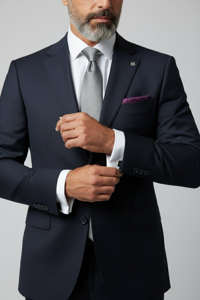Man wearing navy slim fit suit with paisley lining and gray tie.