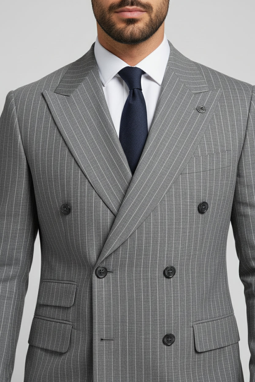Man wearing gray pinstripe double-breasted suit with tailored fit and navy tie.