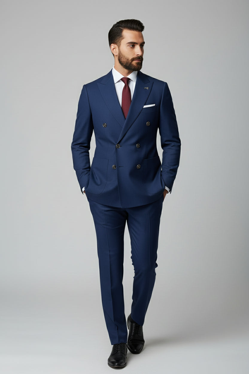 Man wearing navy double-breasted suit with peak lapels and tailored fit.