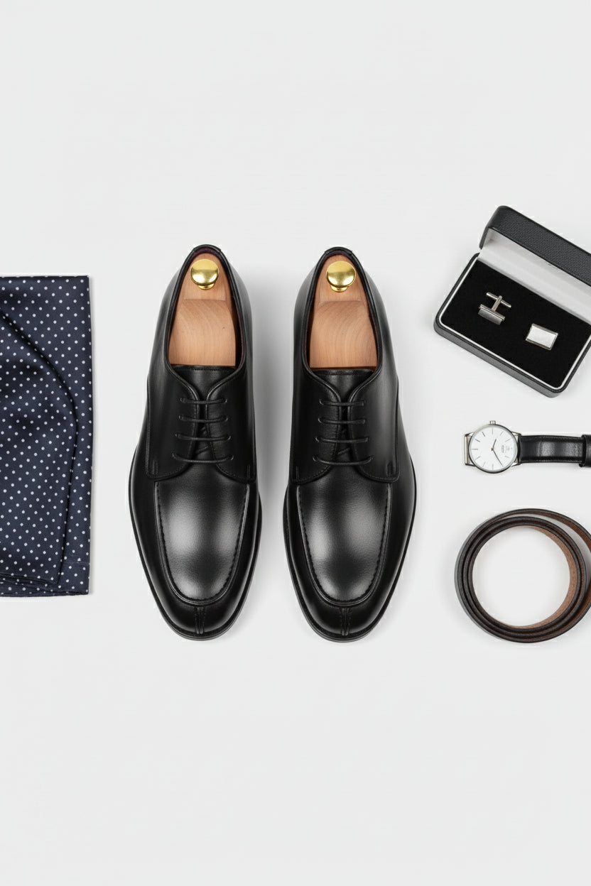 Black leather lace-up dress shoes styled with a navy polka dot pocket square.