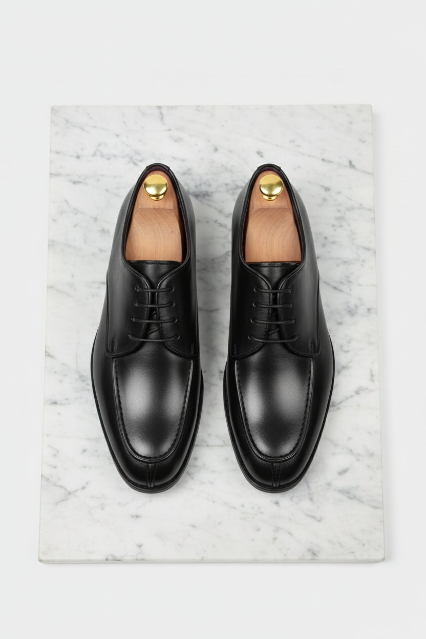 Black leather lace-up dress shoes with sleek design and polished finish.