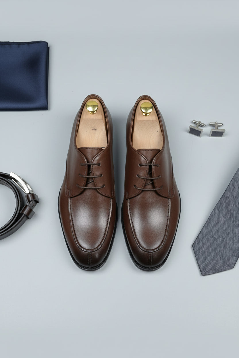 Brown leather lace-up dress shoes with sleek design, ideal for formal occasions.