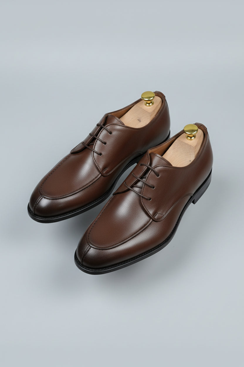 Brown leather lace-up dress shoes with classic design, ideal for formal events.