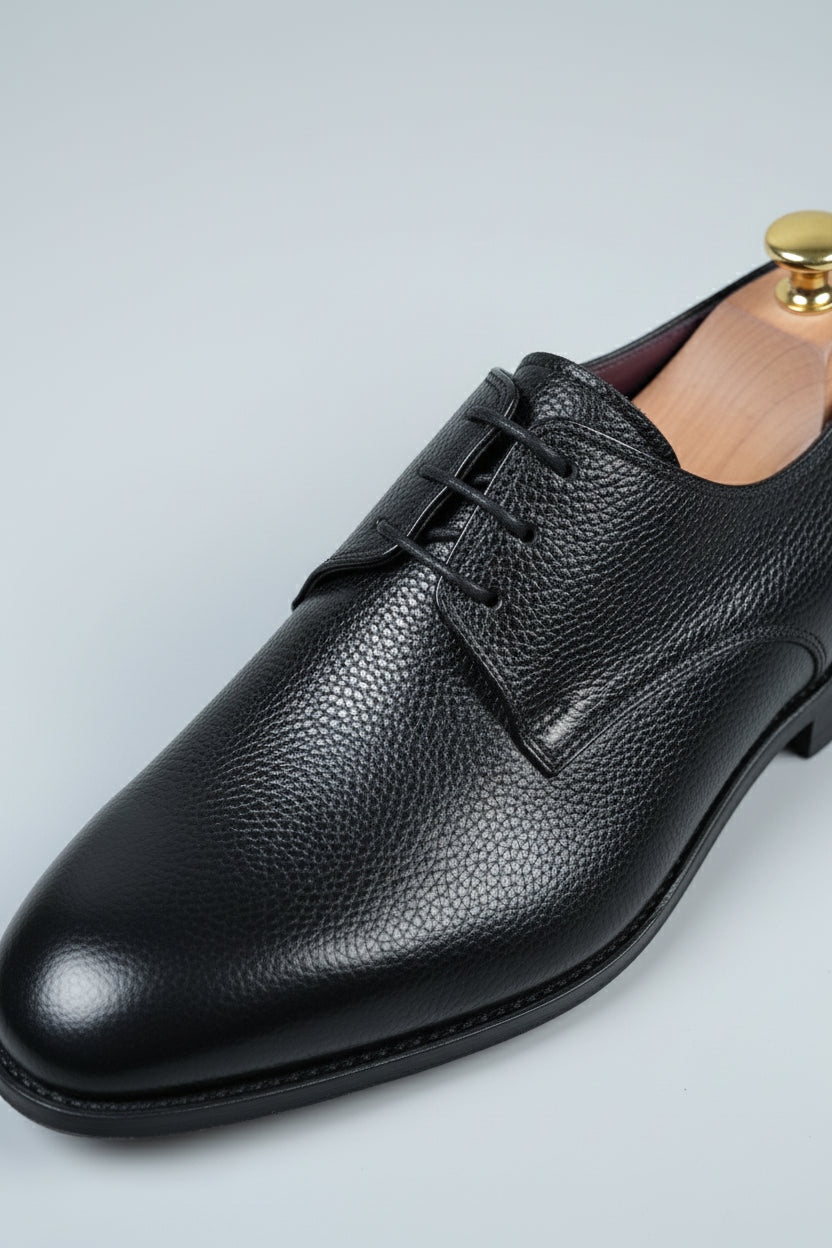 Black leather lace-up dress shoes with textured finish, ideal for formal occasions.
