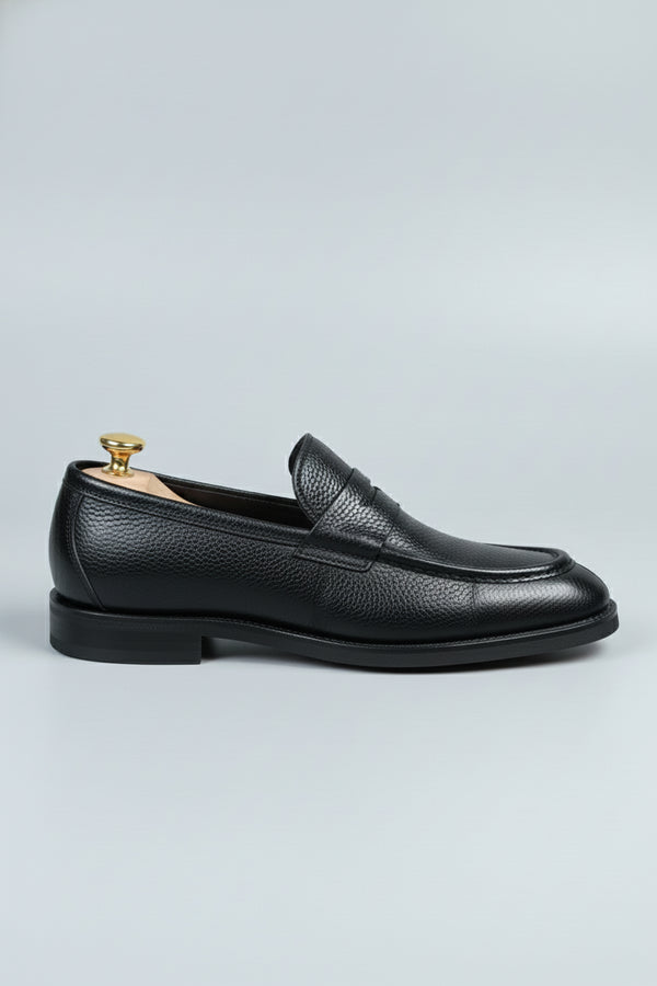 Black leather loafer with textured finish, ideal for formal and casual occasions.