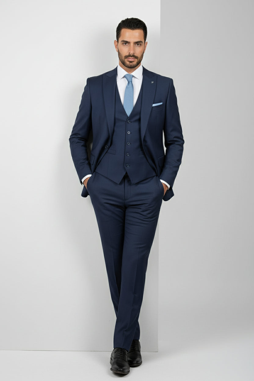 Man wearing black tailored suit with satin lapels and modern fit.