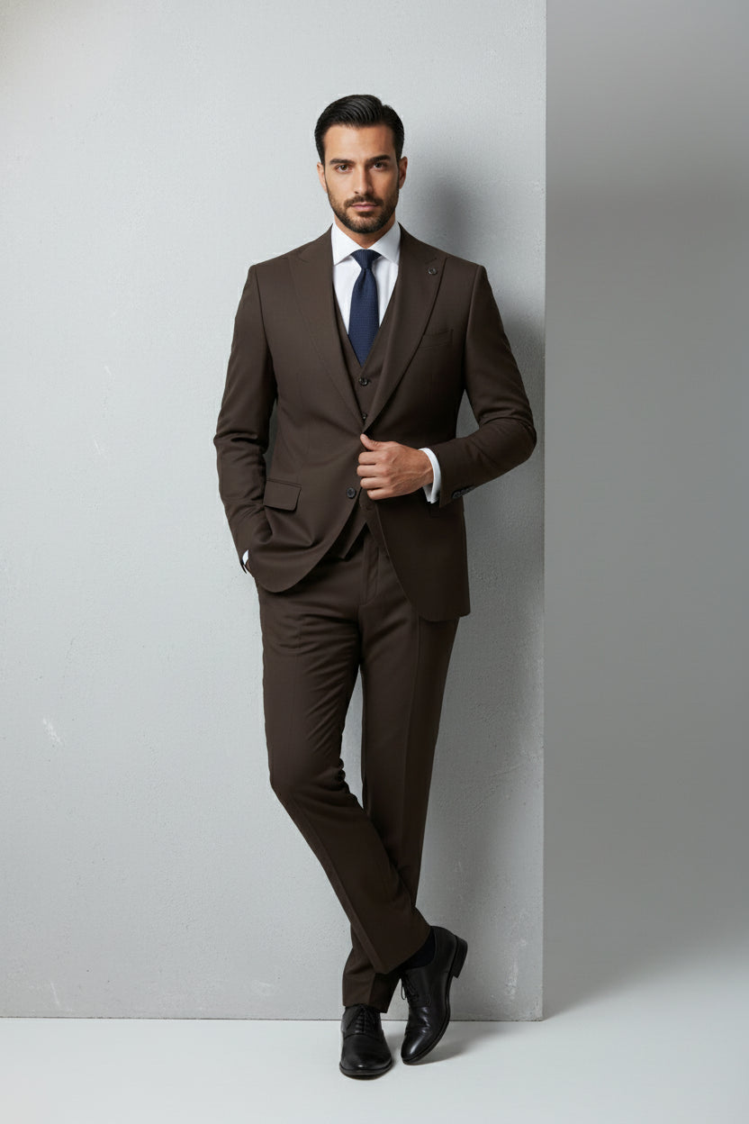 Man wearing brown slim fit three-piece suit with matching vest and tie.