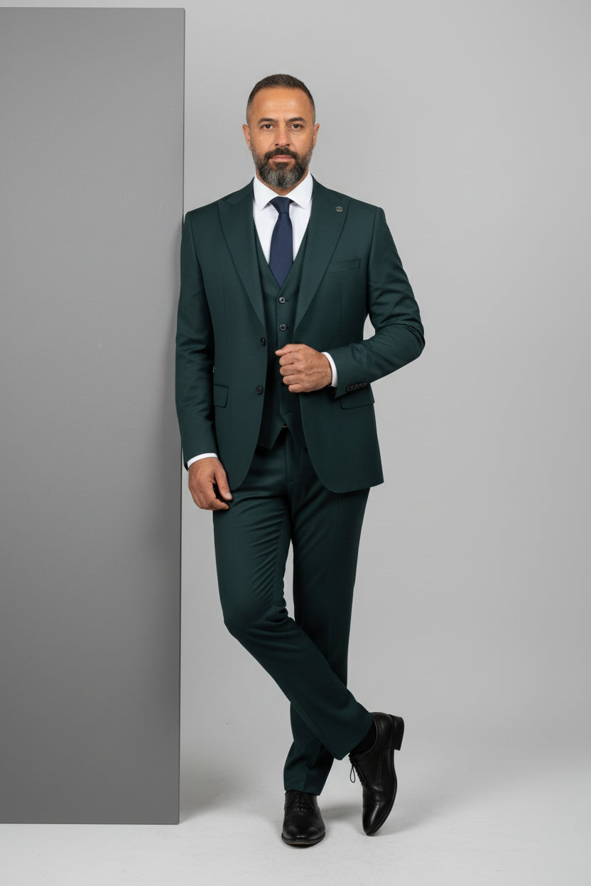 Man in tailored green three-piece suit with notch lapel, exuding modern elegance.