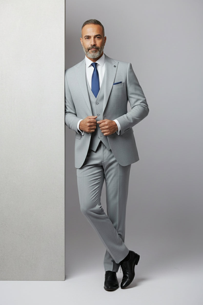 Man in light grey three-piece suit with tailored fit, perfect for weddings or business meetings.