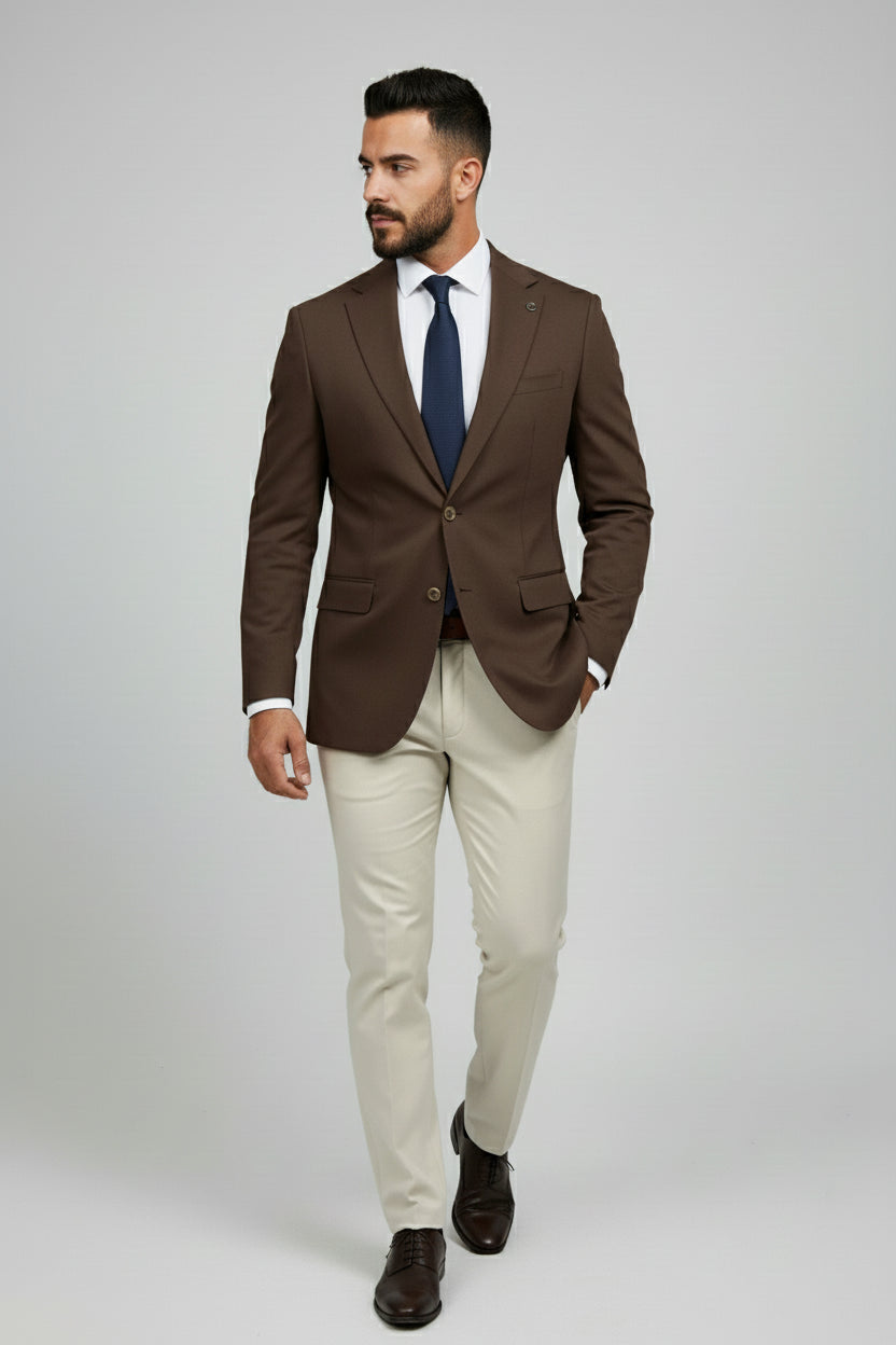 Man wearing brown and beige slim-fit combination suit with a navy tie.