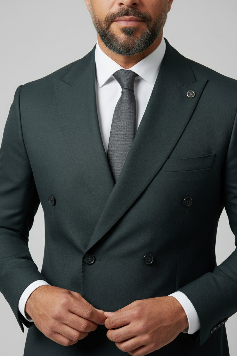 Man wearing dark green double-breasted suit with peak lapels and slim fit.