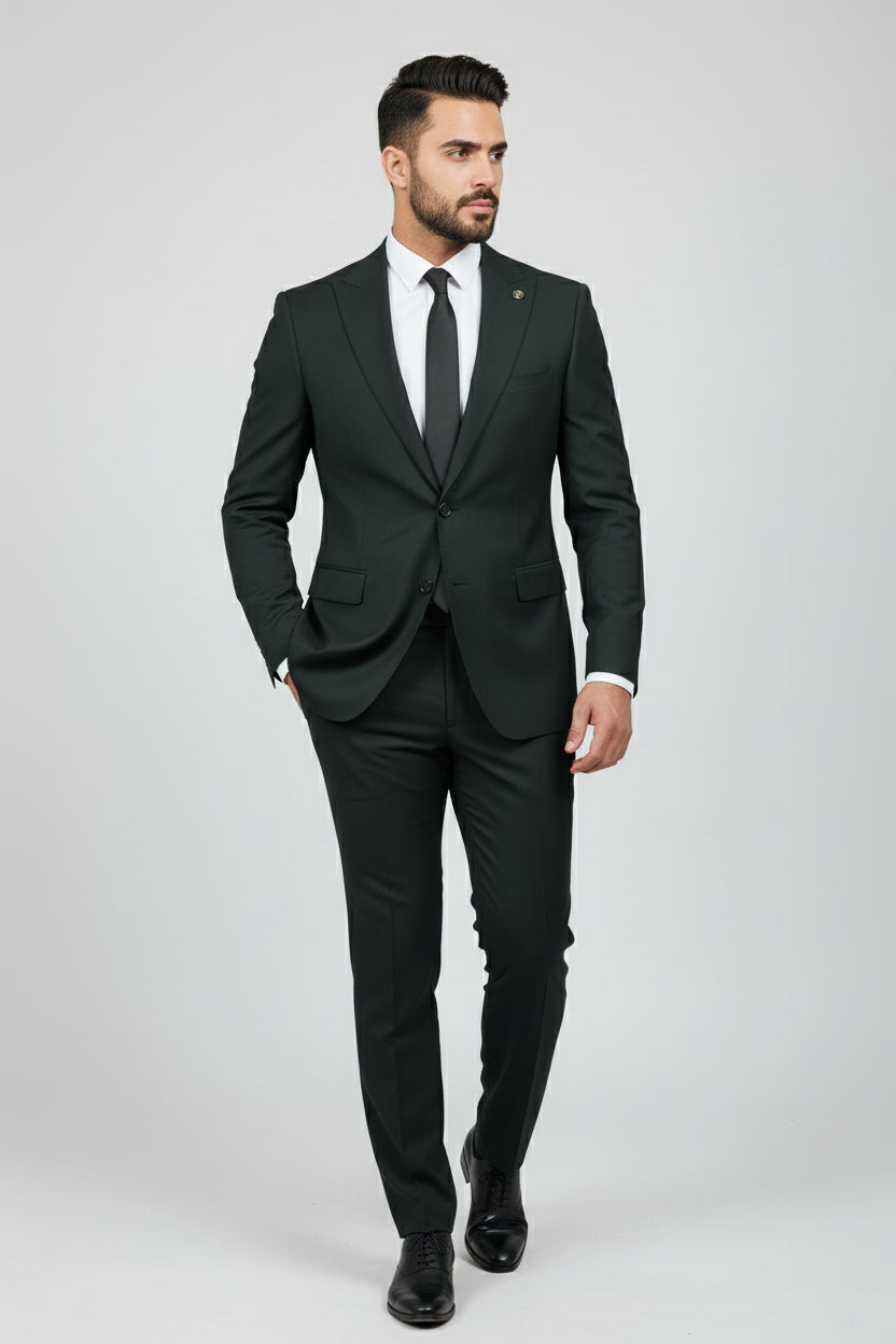 Man wearing tailored dark green two-piece suit with peak lapels for formal occasions.