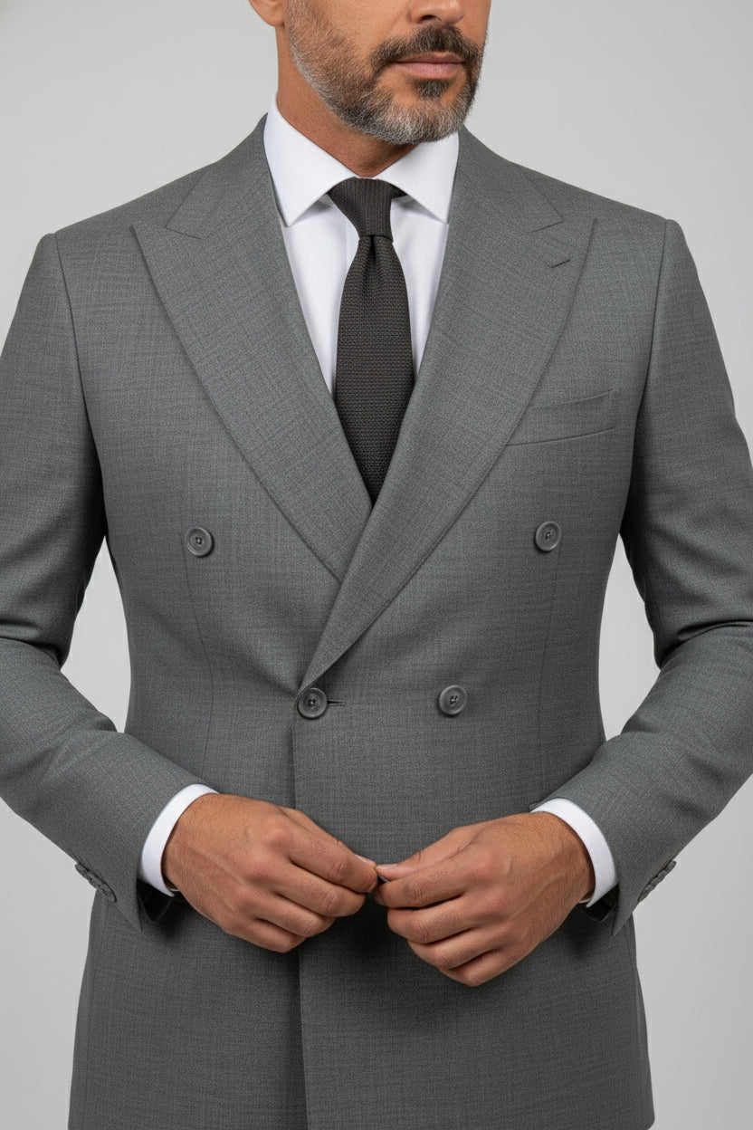 Man wearing gray double-breasted tailored suit with a white shirt and tie.