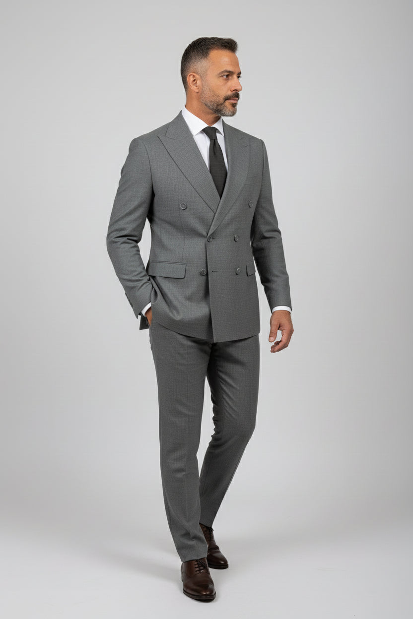 Man wearing gray double-breasted tailored suit with matching trousers and tie.