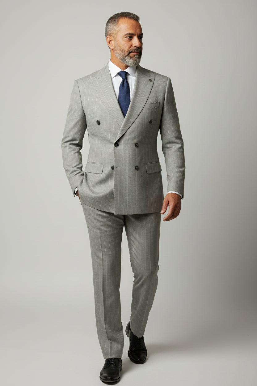 Man in beige double-breasted pinstripe suit with tailored fit and navy tie.